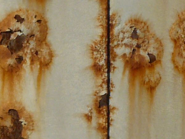 White metal texture covered by many small red spots and patches of rust.